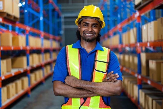 Smiling employee at the factory standing with arms crossed