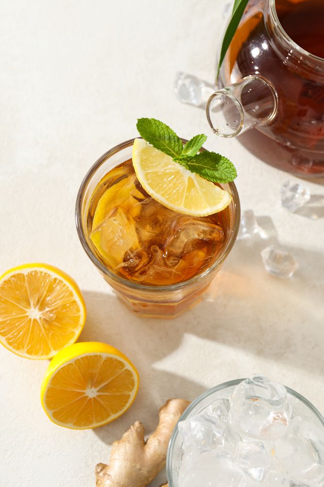 Cold tea with ice, orange slices and mint leaves and ginger