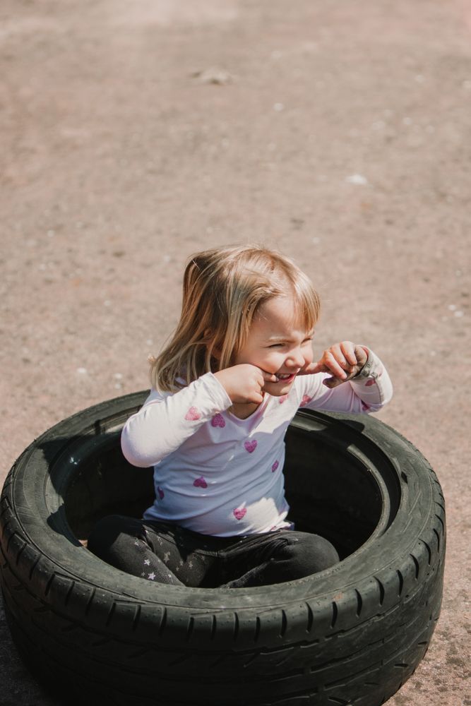 Little girl sitting inside tire
