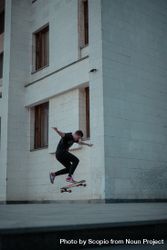 Man skate boarding beside a building 5w8Ry4