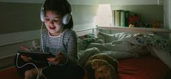 Girl with headphones looking at the tablet