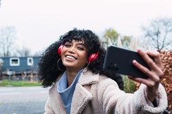 Black woman taking selfie on street