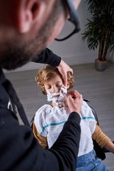 Boy shaving in a barbershop