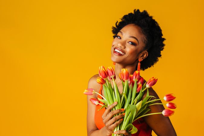 Beautiful Black woman holding bouquet of tulips