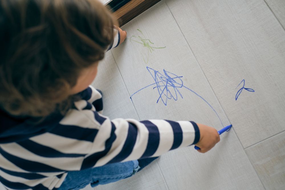 Anonymous kid drawing on floor
