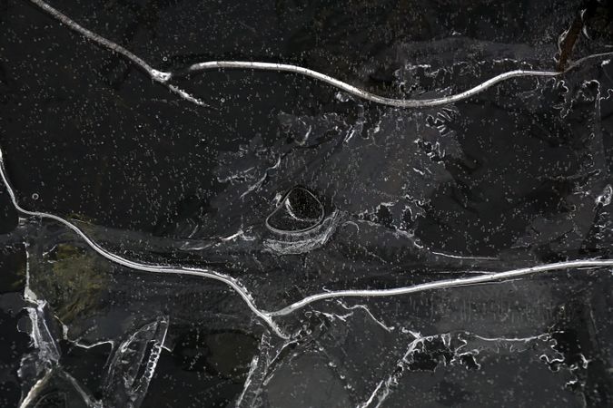Fragment of thin ice on dark frozen river