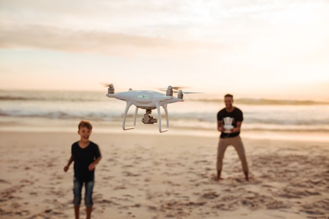 Drone being flown by father and son smiling