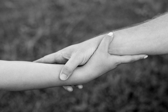 Grayscale photo of two hands holding