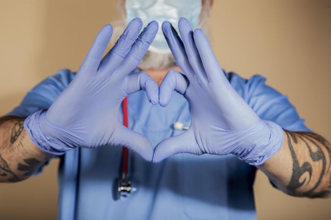 Close-up shot of a medical practitioner making a heart shape with his hands