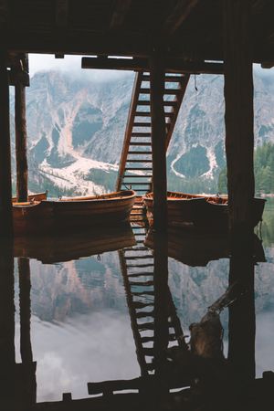 Moored wooden boats at pier on lake in mountains