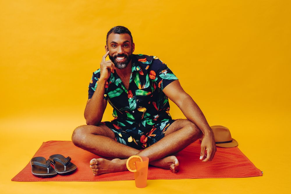 Black male sitting on towel and looking at camera curiously