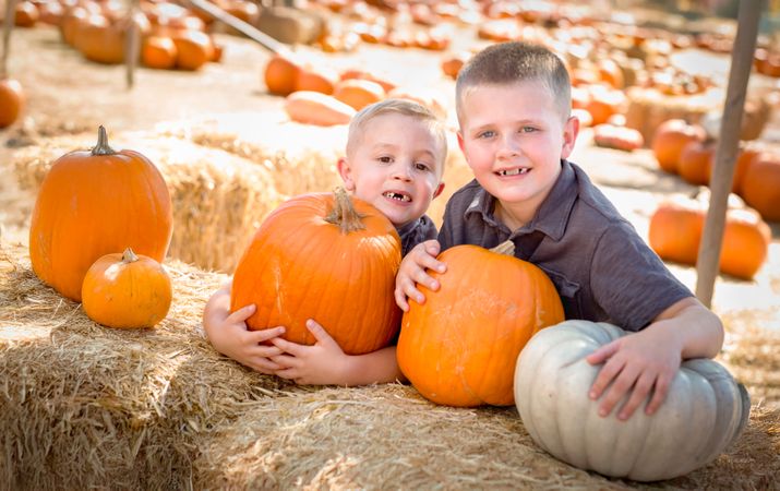 Two Boys Having Fun at the Pumpkin Patch .on a Sunny Fall Day.