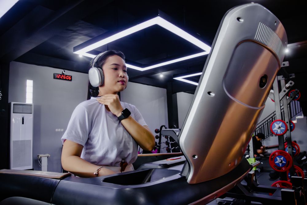 Determined woman exercising on treadmill in modern gym setting