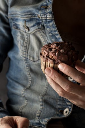 Crop woman with chocolate banana muffin