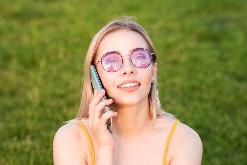 Woman in bright sunglasses talking on phone