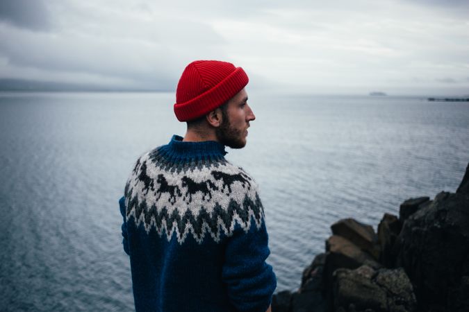 Profile of man in wool sweater on rugged Icelandic coast