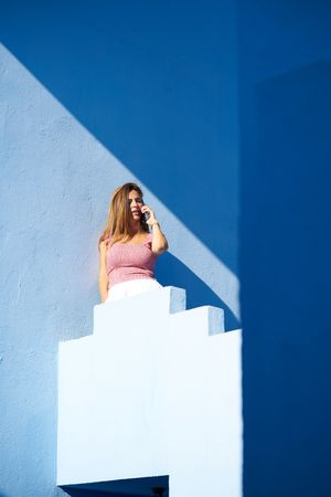 Woman on a blue building using smartphone