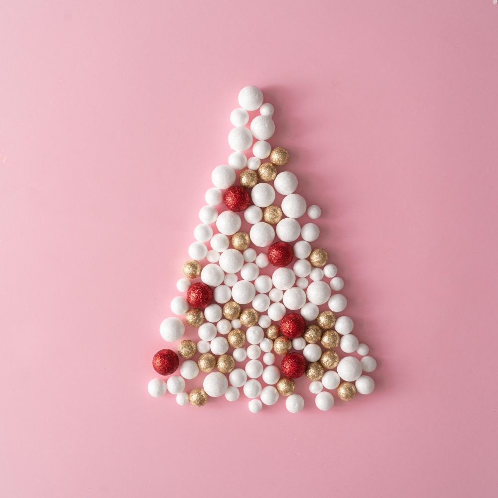 Christmas tree made of gold and red glitter ball decoration on pink space