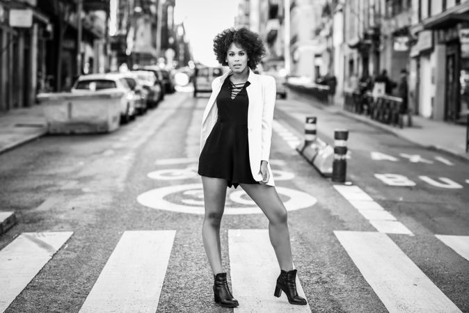 B&W female in short dress and blazer standing on street