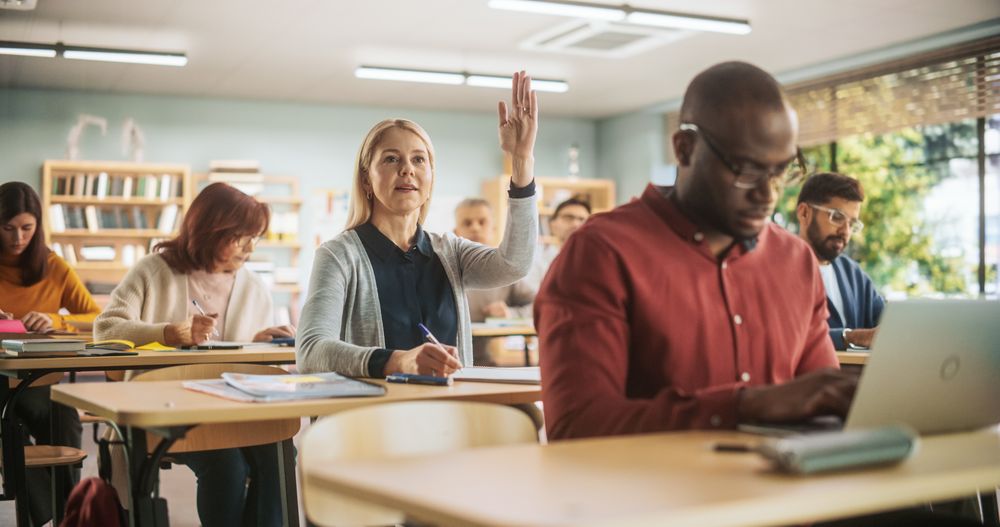 Female Raising Hand and Asking Teacher a Question During a Lecture in Adult Education Course in School