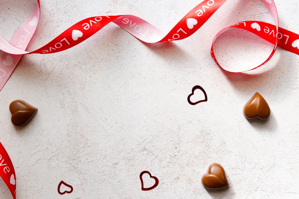 Valentine's Day Concept- Red ribbon with heart chocolates.