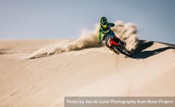 Enduro rider in action accelerating the motorbike after the corner on sand dune 5znvn5
