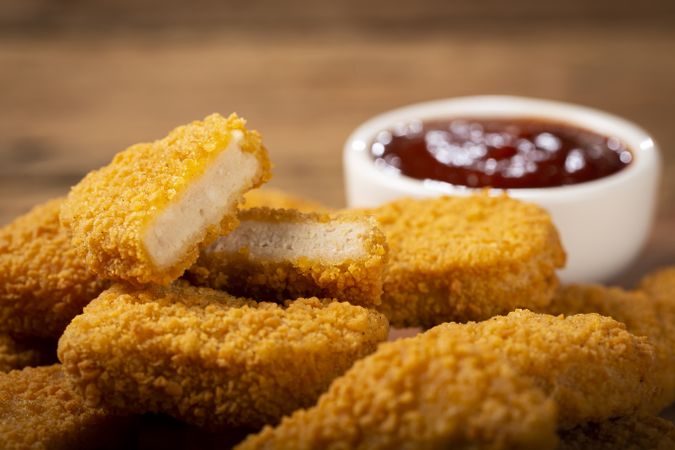 Fried chicken nuggets with ketchp and rose sauce.