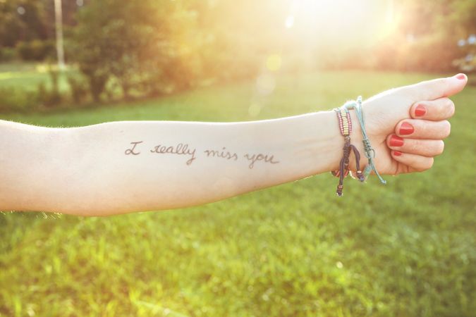 Female arm with text -I really miss you- written on skin