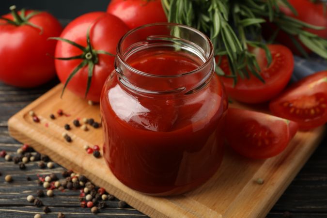 Composition with tomatoes and sauce on wooden background. Ripe vegetable