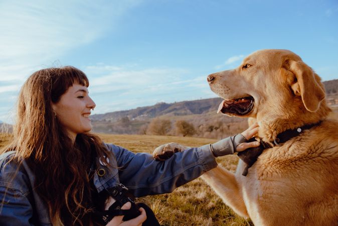 Woman taking photo of dog between field