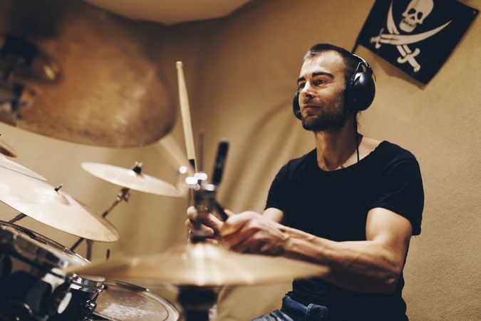Man with headphones playing on drums