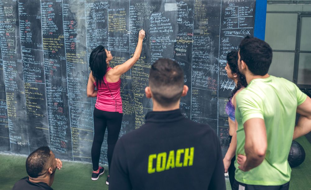 Athlete woman writing down results on the gym board