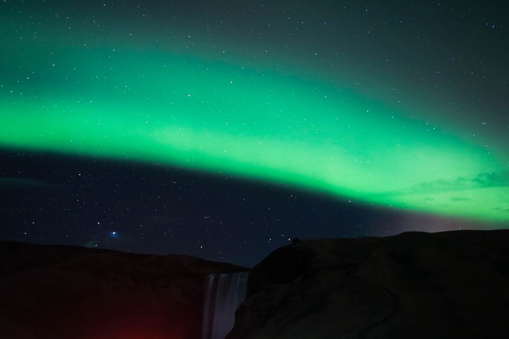 Aurora above waterfall
