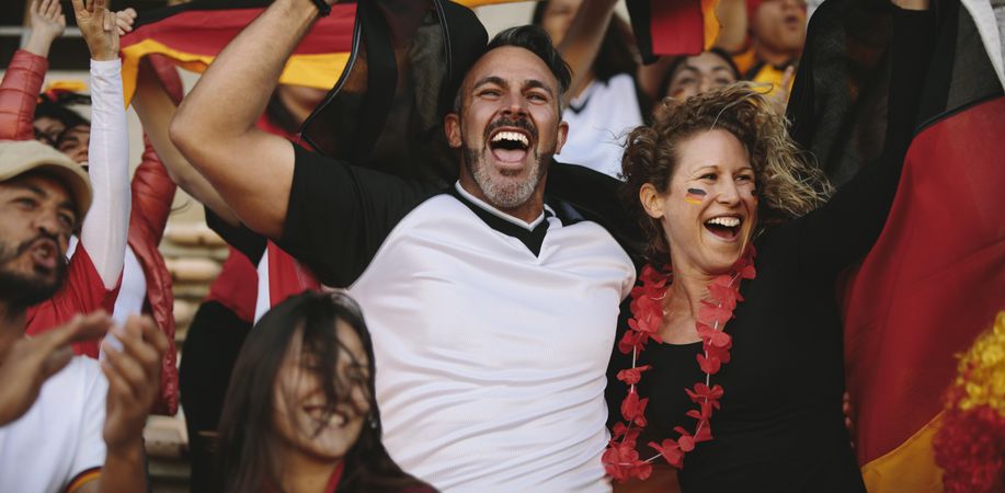 Group of multi-ethnic soccer fans cheering from stadium fan zone