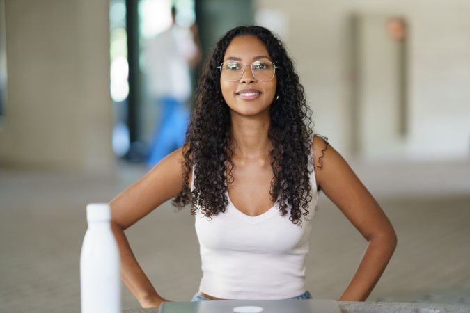 A Confident Young Woman Happily Smiling at the Camera While in a Casual and Relaxed Setting