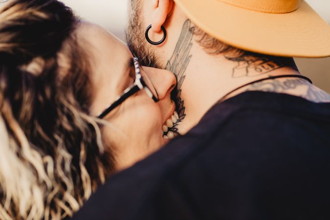 Young woman biting guy in tattoos