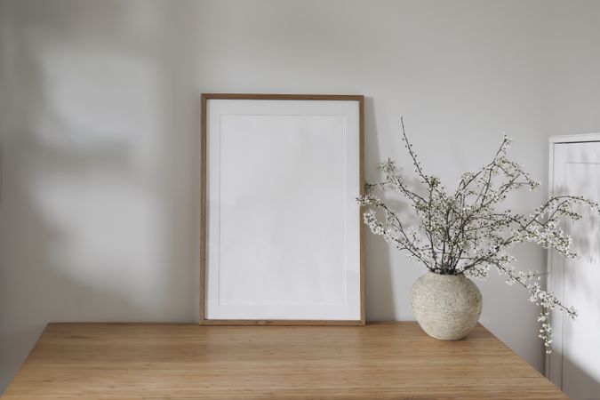 Vertical wooden picture frame, poster mockup in sunlight.