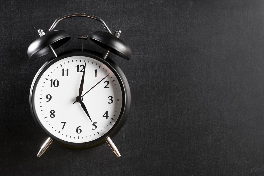 Alarm clock showing 5 o’clock against a dark background
