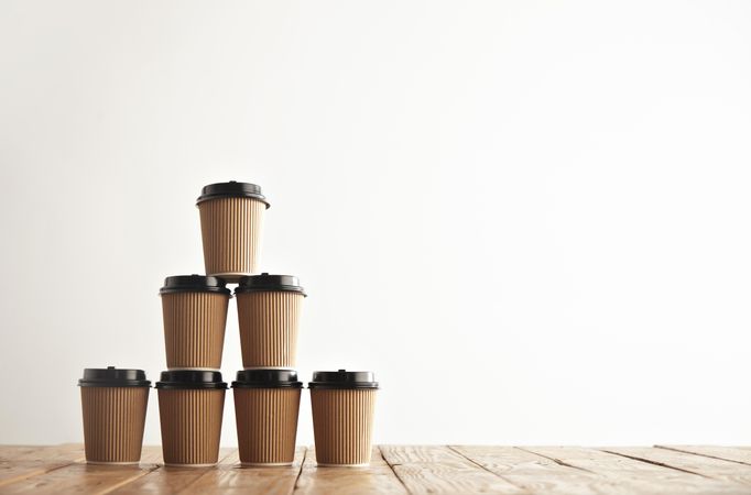 To go coffee cups stacked on wooden table
