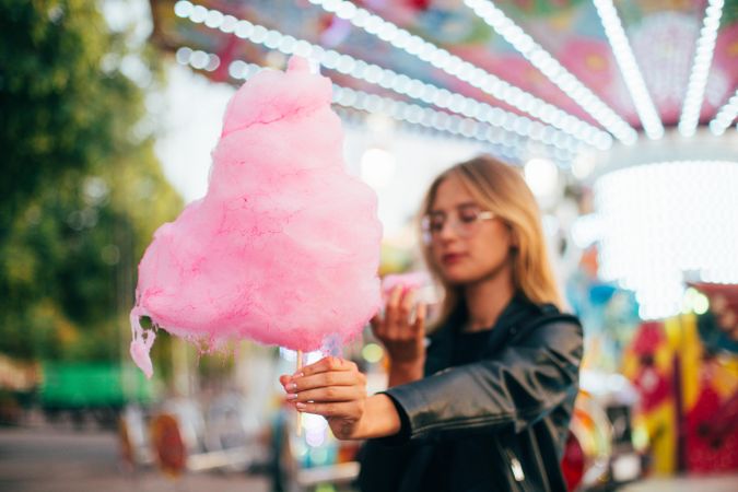 Woman holding large cotton candy in a fairground