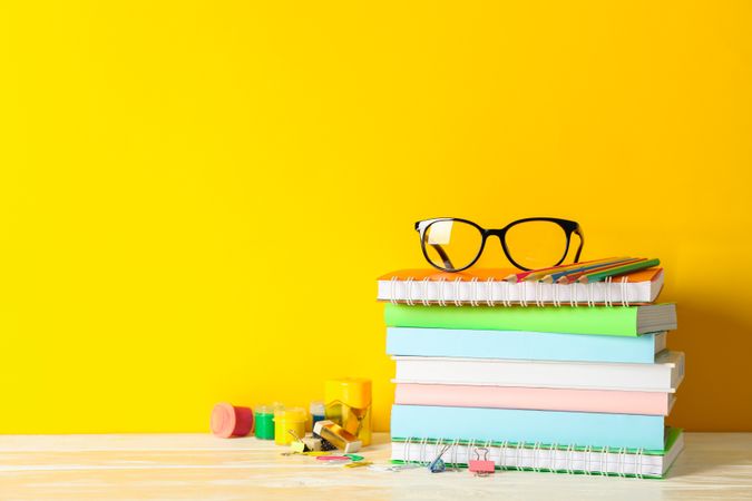 School supplies on wooden table against color background, space for text