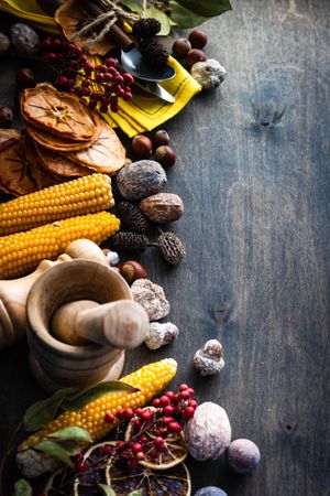 Fall flatlay with nuts, berries, vegetable and fruits on dark wooden background with copy space