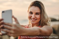 Woman taking selfie on beach 0yN9a5