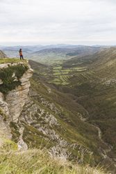 Man standing on cliff near valley