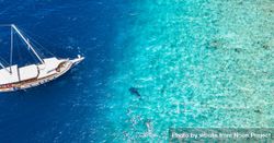 Aerial shot of boat with people swimming in tropical waters, wide 5pZQgb