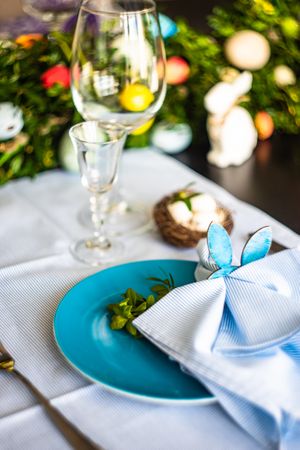 Easter table setting with rabbit napkin ring on pastel blue napkin