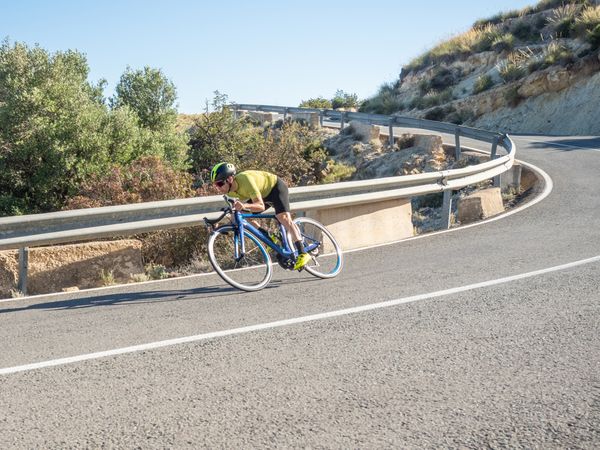 healthy man riding a bicycle on a mountain road in a sunny day