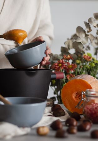 Faceless chef cooking pumpkin and chestnut cream soup