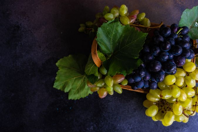 Box of fresh green & red grapes on kitchen counter with copy space