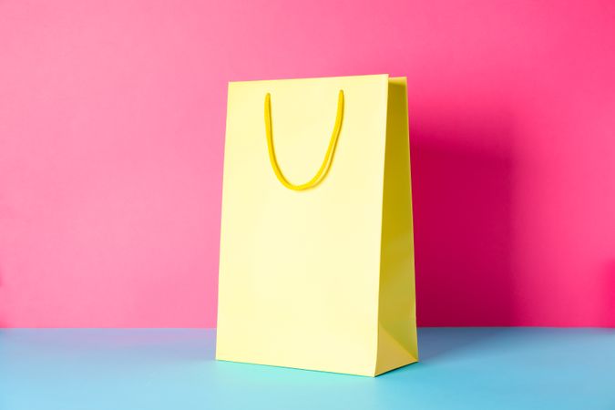 Yellow paper bag on multicolor background, space for text